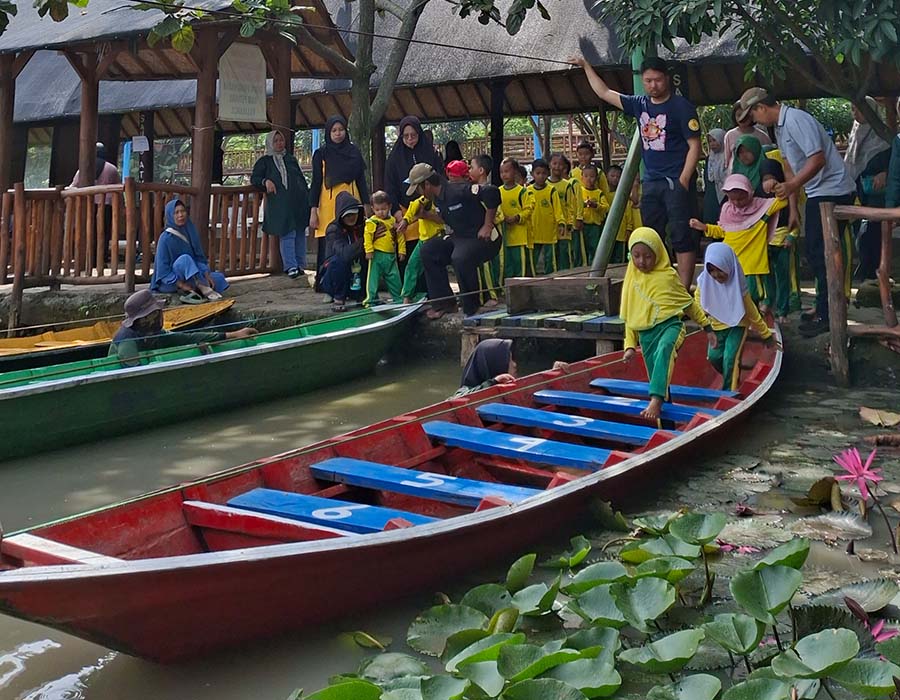 Anak-anak menaiki perahu di area wisata
